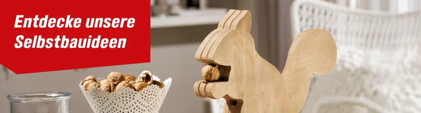 Ein Nussknacker in Eichhörnchenform aus Holz, der eine Walnuss hält.